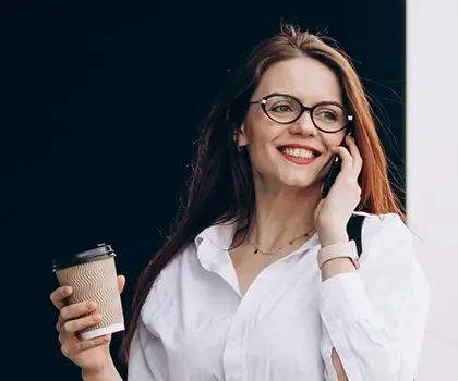 Business woman walking with coffee and talking on the phone