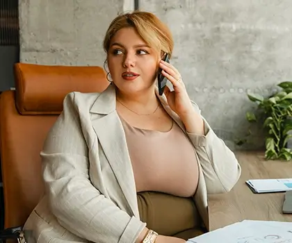 A business professional sitting at a desk on the phone